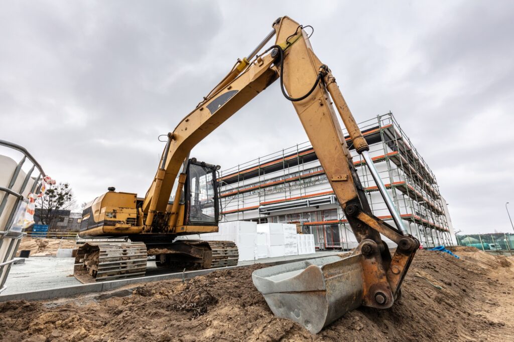 Excavator or digger working on office and warehouse building construction.
