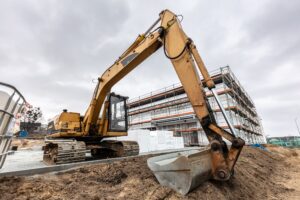 Excavator or digger working on office and warehouse building construction.
