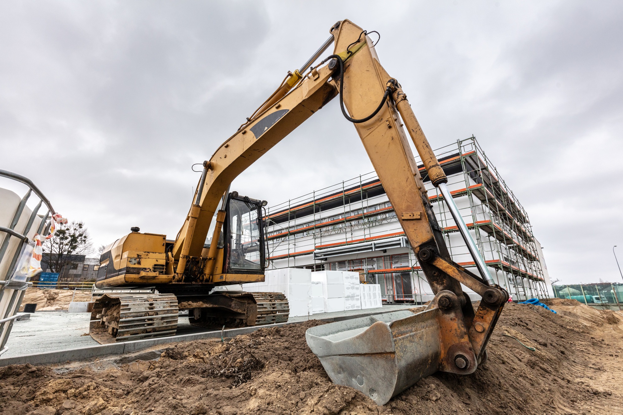 Excavator or digger working on office and warehouse building construction.